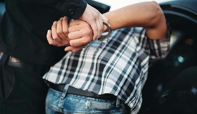A law enforcement officer placing handcuffs on a person