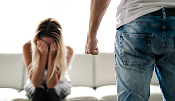 A man of clenched fist standing front of a woman