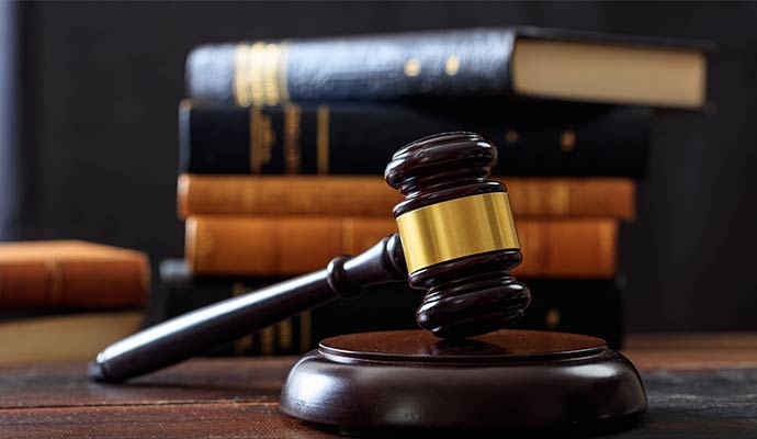 A wooden judge's gavel resting on a sound block