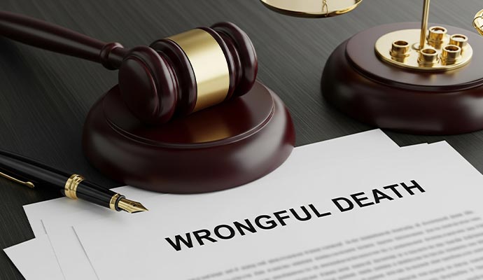 Documents prominently titled WRONGFUL DEATH on a dark wooden desk