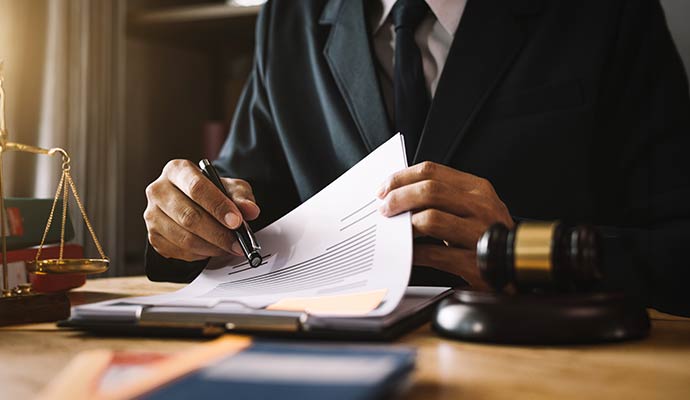 A professional in a dark suit reviewing and marking a document