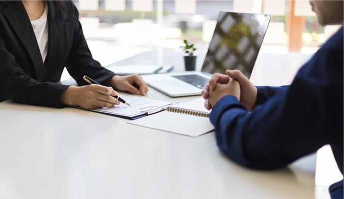 Professional reviewing documents with a client during a consultation at a desk