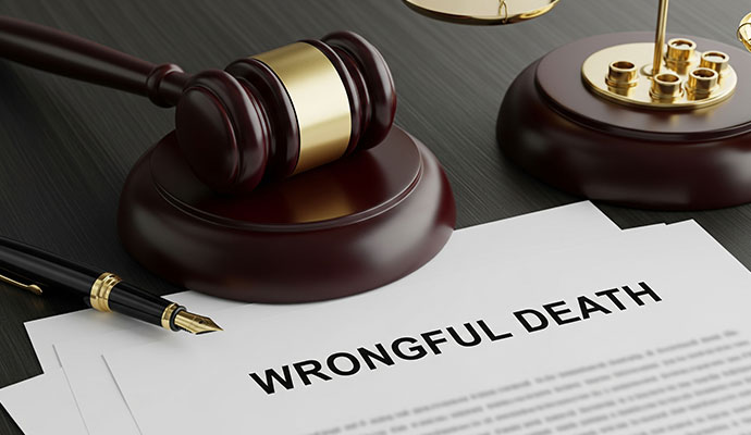 Wrongful death document with gavel pen and legal materials on desk