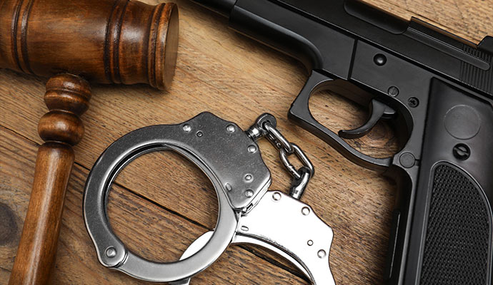 Wooden, gavel, handcuffs and handgun on the table 